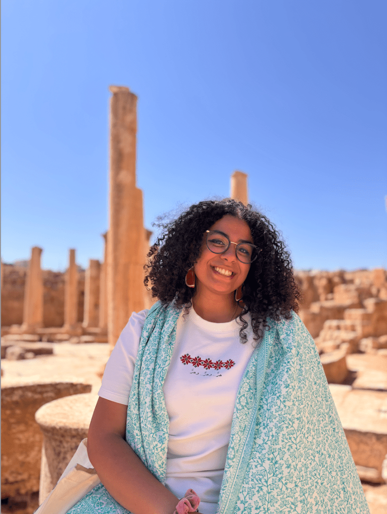 Sandra Y. headshot in a desert with a light blue scarf around her neck